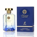 Maison Alhambra Kismet Lunar Magic 100ml — A clear glass perfume bottle with a gold cap and blue gradient base sits next to its matching blue and gold box on a white background. | Maison Alhambra Kismet Lunar Magic 100ml — Botol minyak wangi kaca jernih dengan penutup emas dan tapak gradien biru terletak di sebelah