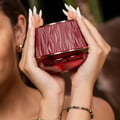 Maison Asrar Kiss My Lips by Maison Asrar 90ml EDP Unisex — Red cylindrical packaging with gold accents, featuring 'KISS MY LIPS' and 'MAISON ASRAR' text. The perfume bottle has a textured, deep red cap and a black base with gold trim, displaying 'Kiss My Lips' and volume details.