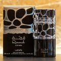 Lattafa Qimmah Eau De Parfum for Men 100ml — A black perfume box with a clear plastic overlay featuring a black and silver giraffe-like pattern sits next to a matching black perfume bottle with a silver, patterned cage-like cap. | Lattafa Qimmah Eau De Parfum for Men 100ml — Kotak minyak wangi hitam dengan lapisan