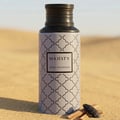 Maison Asrar Majesty by Maison Asrar 100ml EDP Unisex — A grey bottle with a repeating black quatrefoil pattern and a black textured cap, featuring a black label with 'MAJESTY' and 'ROYAL COLLECTION' text.