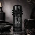 Lattafa Musamam Black Intense — A black snake coiled around the cap of a dark glass perfume bottle, resting on a textured black stand with a snake-skin pattern. | Lattafa Musamam Black Intense — Seekor ular hitam melingkar di sekeliling penutup botol minyak wangi kaca gelap, diletakkan di atas tapak hitam bertekstur