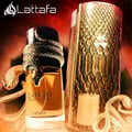 Lattafa Musamam Eau De Parfum 100ml by Lattafa — A gold snake wraps around a clear glass perfume bottle filled with amber liquid, next to a textured brown cylindrical box. | Lattafa Musamam Eau De Parfum 100ml by Lattafa — Ular emas melilit botol minyak wangi kaca jernih berisi cecair ambar, bersebelahan kotak