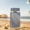 Lattafa Najdia Intense Men Lattafa 100ml EDP — A clear glass perfume bottle with a grey cap and a prominent silver leaf design on the front, placed next to its matching grey and blue box with a similar silver leaf motif.