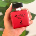 Maison Alhambra Narissa Ruby Rouge Maison Alhambra 100ml — A red perfume bottle and its matching red box are displayed against a white background. | Maison Alhambra Narissa Ruby Rouge Maison Alhambra 100ml — Sebotol minyak wangi merah dan kotak merah yang sepadan dipaparkan berlatarkan putih.