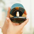 Maison Asrar Never Forget Me by Maison Asrar 90ml EDP Women — Green textured box lid open, revealing a dark bottle with gold accents and textured interior.