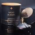 Maison Asrar Night In Paris — Botol minyak wangi hitam bertekstur dengan penutup emas di sebelah kotak silindernya yang hitam dan emas, kedua-duanya bercorak berombak dan tulisan emas.
