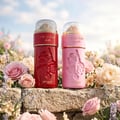 Zimaya Ode to Rose Bella Eau De Parfum — A red perfume bottle with embossed roses and a gold-accented clear cap sits next to its matching red patterned gift box with embossed gold roses. | Zimaya Ode to Rose Bella Eau De Parfum — Botol minyak wangi merah dengan bunga ros timbul dan penutup jernih beraksen emas