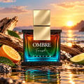 Armaf Ombre Fresh by Armaf 100ml EDP Unisex — Glass perfume bottle with gradient amber-to-teal liquid, gold cap, on a black speckled base, next to its blue gradient box.
