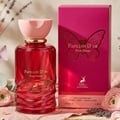 Maison Alhambra Papillon D'Or 100ml Maison Alhambra — A red glass perfume bottle with a pink cap sits next to its matching bright pink box, which features a gold butterfly design. | Maison Alhambra Papillon D'Or 100ml Maison Alhambra — Botol kaca merah dengan penutup merah jambu duduk bersebelahan dengan kotak merah