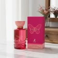 Maison Alhambra Papillon D'Or 100ml Maison Alhambra — A red glass perfume bottle with a pink cap sits next to its matching bright pink box, which features a gold butterfly design. | Maison Alhambra Papillon D'Or 100ml Maison Alhambra — Botol kaca merah dengan penutup merah jambu duduk bersebelahan dengan kotak merah