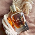 Perfume bottle labeled 'Special Oud' with gold cap on a textured surface
