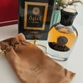 Amnia perfume bottle with brown drawstring bag on a white surface