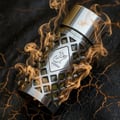 Metallic container with geometric design and brand logo on a stone surface