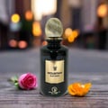 Perfume bottle labeled 'Mountain Nuit Paris' with flowers on a wooden surface