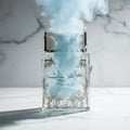 Pure Musk Perfume bottle broken, fog emerging; studio on white marble Malaysia — clear bottle and box, cinematic lighting