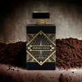 Perfume bottle labeled 'Infini Oud' with gold accents on a textured brown background