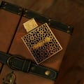 rayhaan elixir perfume bottle with intricate design on a brown leather surface