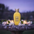Rabab Pulp by Zimaya perfume bottle on garden stone table with jasmine candles golden dusk Malaysia”