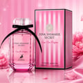 Maison Alhambra Pink Shimmer Secret 100ml — Pink perfume bottle with a black ribbon bow, next to its matching pink striped box, on a white background. | Maison Alhambra Pink Shimmer Secret 100ml — Botol minyak wangi merah jambu dengan reben hitam, bersebelahan kotak berjalur merah jambu yang sepadan, di atas latar