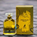 Maison Alhambra Precious Gold 80ml by Maison Alhambra — A gold-themed perfume box and bottle are displayed side-by-side against a white background. The box features abstract gold brushstrokes and a deer silhouette, while the bottle contains golden liquid and has a heart-shaped charm. | Maison Alhambra Precious Gold