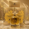Maison Alhambra Precious Gold 80ml by Maison Alhambra — A gold-themed perfume box and bottle are displayed side-by-side against a white background. The box features abstract gold brushstrokes and a deer silhouette, while the bottle contains golden liquid and has a heart-shaped charm. | Maison Alhambra Precious Gold