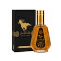 Ard Al Zaafaran Qaed Al Fursan — A gold-capped glass perfume bottle with amber liquid sits next to its black and gold box featuring a running horse graphic. | Ard Al Zaafaran Qaed Al Fursan — Botol kaca bertutup emas dengan cecair berwarna ambar duduk bersebelahan dengan kotak hitam dan emasnya yang menampilkan grafik