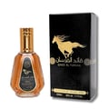 Ard Al Zaafaran Qaed Al Fursan — A gold-capped glass perfume bottle with amber liquid sits next to its black and gold box featuring a running horse graphic. | Ard Al Zaafaran Qaed Al Fursan — Botol kaca bertutup emas dengan cecair berwarna ambar duduk bersebelahan dengan kotak hitam dan emasnya yang menampilkan grafik