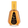 Ard Al Zaafaran Qaed Al Fursan — A gold-capped glass perfume bottle with amber liquid sits next to its black and gold box featuring a running horse graphic. | Ard Al Zaafaran Qaed Al Fursan — Botol kaca bertutup emas dengan cecair berwarna ambar duduk bersebelahan dengan kotak hitam dan emasnya yang menampilkan grafik