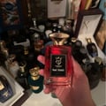 Bujairami Red Static — Red perfume bottle with gold cap next to matching red box with gold logo