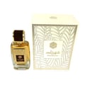 Ard Al Zaafaran Shahrazad Eau De Parfum — A white box with gold leaf pattern and a clear glass perfume bottle with gold accents and amber liquid, set against a white background. | Ard Al Zaafaran Shahrazad Eau De Parfum — Kotak putih dengan corak daun emas dan botol minyak wangi kaca jernih dengan aksen emas dan