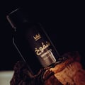 Gulf Orchid Shumookh Parfum 100ml Gulf Orchid — Black perfume bottle and its black and white patterned box with gold crown and Arabic text | Gulf Orchid Shumookh Parfum 100ml Gulf Orchid — Botol minyak wangi hitam dan kotaknya yang bercorak hitam putih dengan mahkota emas dan teks Arab