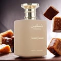Paris Corner Taskeen Caramel Cascade 100ml — A rectangular perfume box with a marble-like pattern in beige and pink hues, accented with gold glitter stripes and gold text. | Paris Corner Taskeen Caramel Cascade 100ml — Peti minyak wangi berbentuk segi empat dengan corak seperti marmar dalam warna beige dan merah