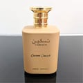 Paris Corner Taskeen Caramel Cascade 100ml — A rectangular perfume box with a marble-like pattern in beige and pink hues, accented with gold glitter stripes and gold text. | Paris Corner Taskeen Caramel Cascade 100ml — Peti minyak wangi berbentuk segi empat dengan corak seperti marmar dalam warna beige dan merah
