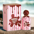 Grandeur Tubbees Chocolate Fudge — A perfume bottle with a chocolate-colored spherical cap and pink and white striped body, with chocolate drips cascading down. Next to it is the product box with the same design. | Grandeur Tubbees Chocolate Fudge — Botol minyak wangi dengan penutup bulat berwarna coklat dan badan