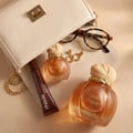 Maison Asrar Vanilla Voyage — Amber glass perfume bottle with a textured peach cap and gold trim, next to its peach box with a perfume silhouette.