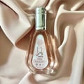 Ard Al Zaafaran Yara Eau De Parfum 50ml — Pink floral patterned box next to a faceted pale pink perfume bottle with a silver cap. | Ard Al Zaafaran Yara Eau De Parfum 50ml — Kotak bercorak bunga merah jambu di sebelah botol minyak wangi merah jambu pucat berfaset dengan penutup perak.