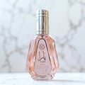 Ard Al Zaafaran Yara Eau De Parfum 50ml — Pink floral patterned box next to a faceted pale pink perfume bottle with a silver cap. | Ard Al Zaafaran Yara Eau De Parfum 50ml — Kotak bercorak bunga merah jambu di sebelah botol minyak wangi merah jambu pucat berfaset dengan penutup perak.